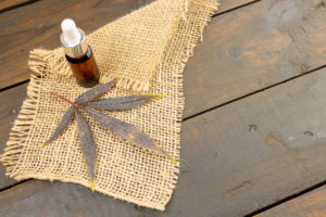 Image of cbd oil in bottle on wooden background. Cbd oil, medical marihuana, cannabis medicament concept.